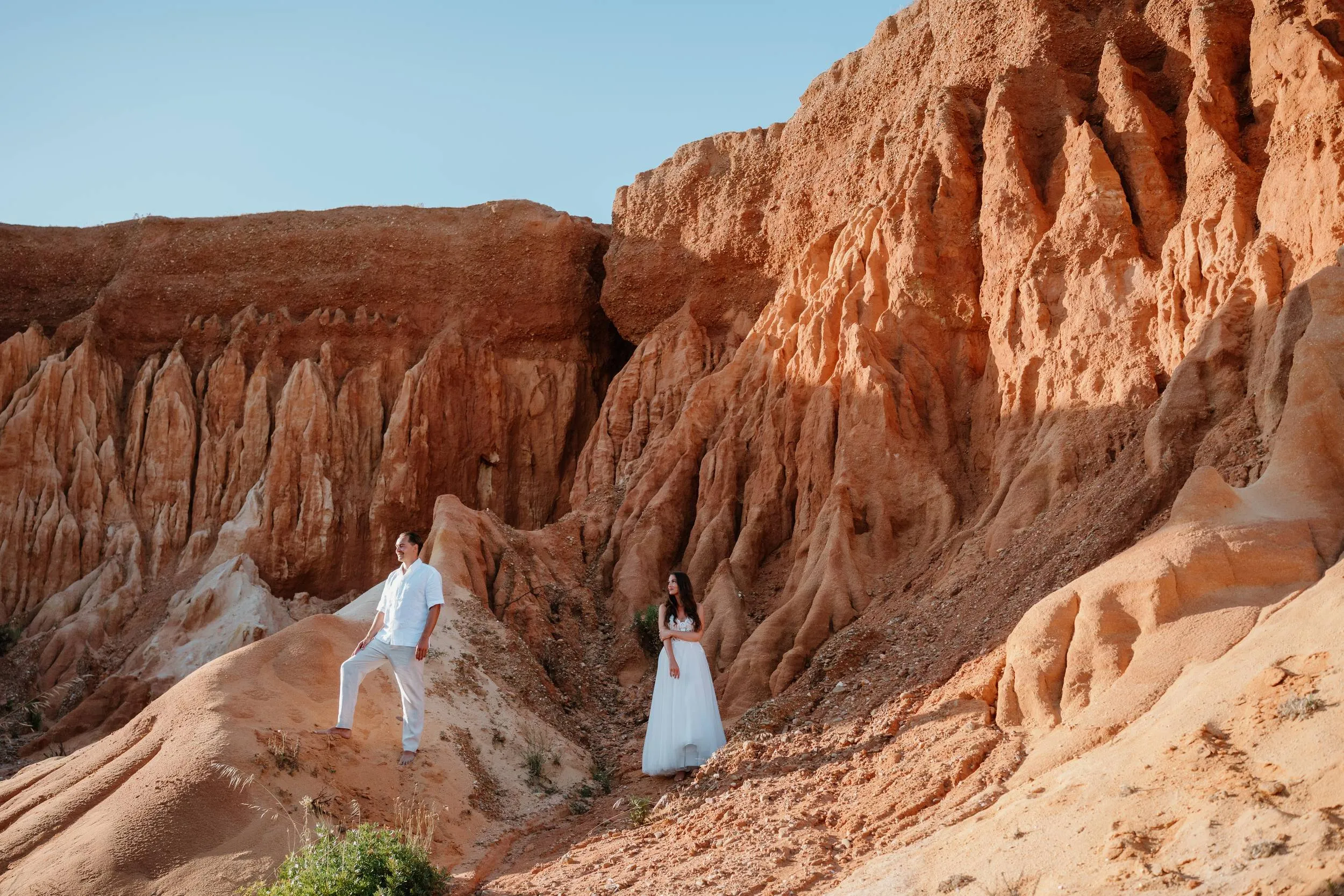 Bride and groom among the red cliffs of the Algarve