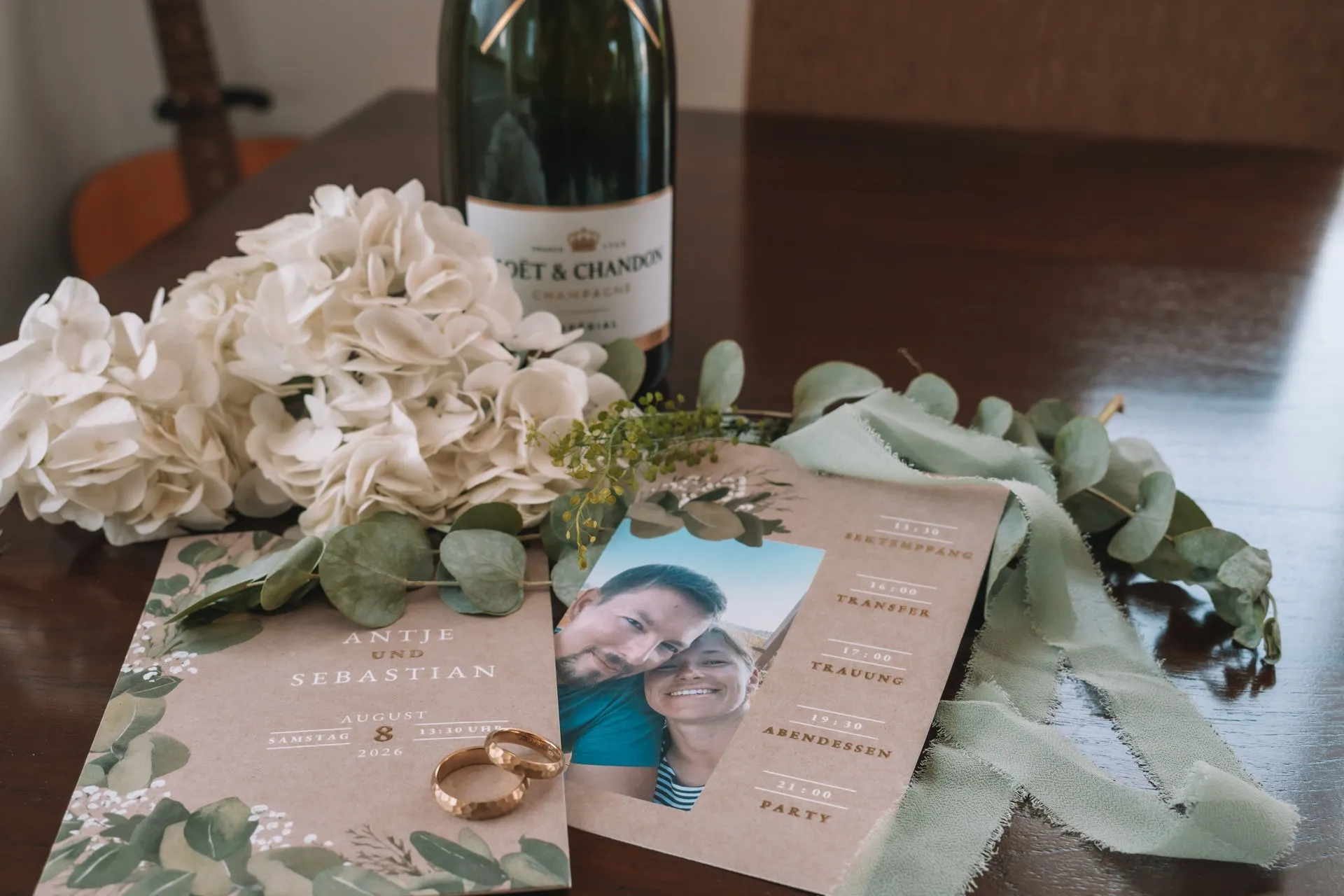 Convite de casamento com eucalipto, alianças e flores